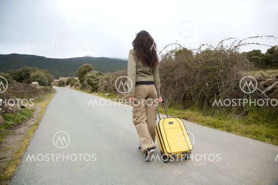woman on road with suitcase