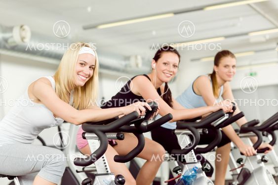 Fitness young woman on gym bike spinning