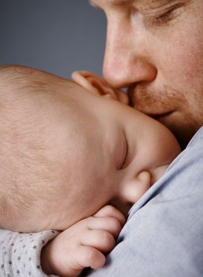 Closeup photo of father kissing newborn baby�