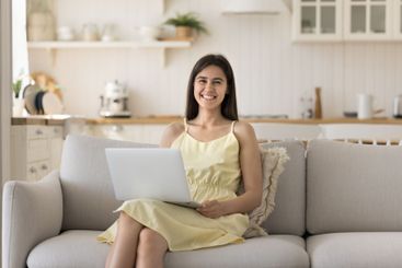 Portrait happy beautiful young woman sitting on couch...