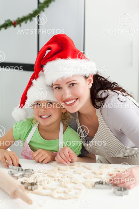 Beautiful mother and daughter cooking Christmas biscuits