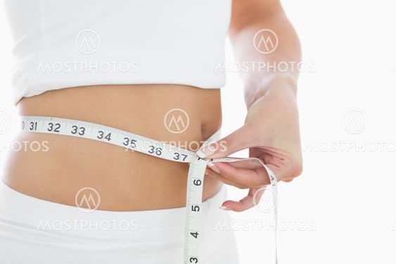 Close-up midsection of woman measuring waist