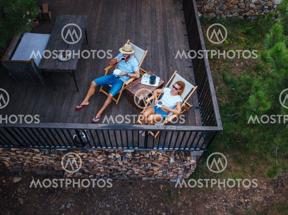 Young couple drinking coffee on terrace, aerial view