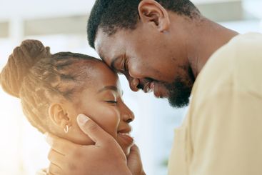 Forehead, care or black couple hug in home living room...