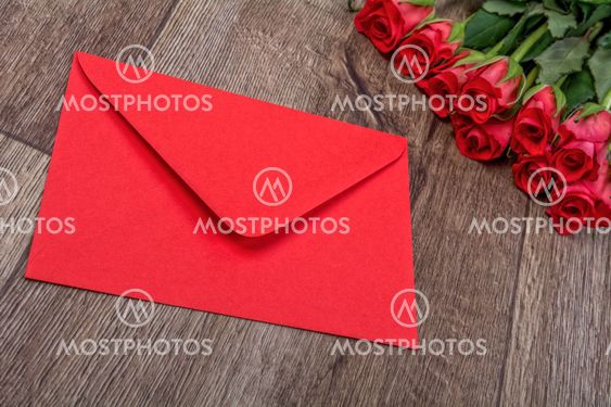 Red envelope and roses on a wooden background