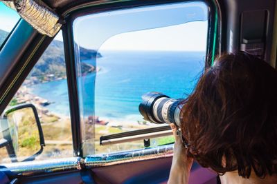 Tourist taking photo with camera on seacoast Greece