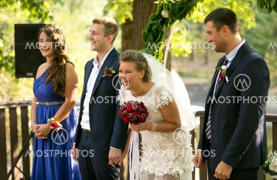 laughing bride and groom posing at outdoor wedding ceremony