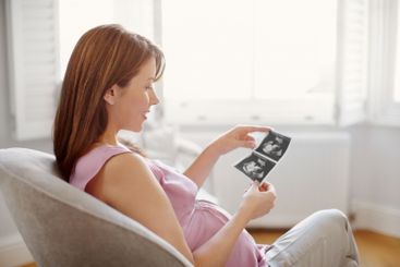 Woman, home and smile for pregnancy with scan of baby...