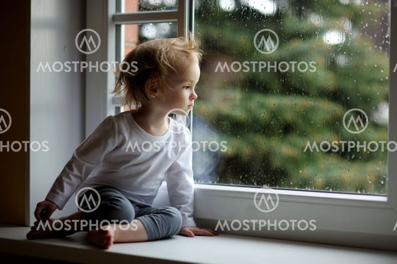 Adorable toddler girl looking though the window