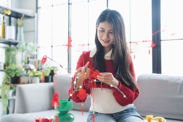 Asian Woman decorated house for Chinese New Year...