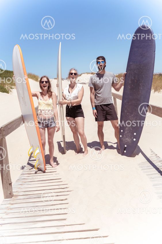 Boys and girls teen surfers with surfboards