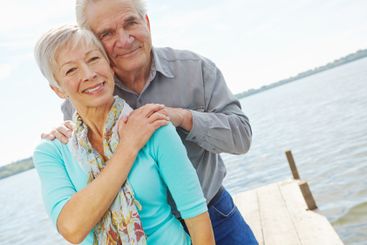 Portrait, travel and senior couple at lake on holiday,...