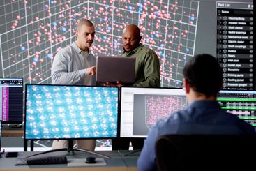 Diverse cyber team in control room monitoring data