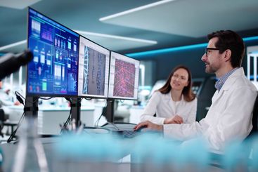 Female scientist using computer to research biotechnology