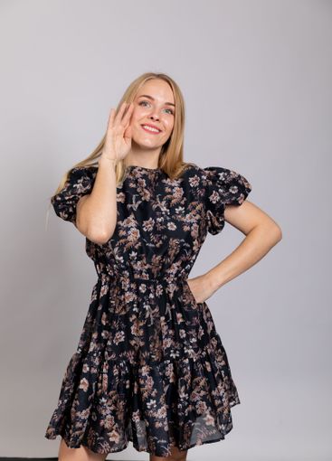 Beautiful woman smiling in summer dress on gray background