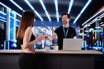 Female athlete paying for gym membership with smartphone