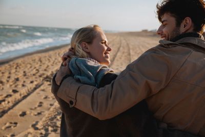 smiling couple embracing on seashore