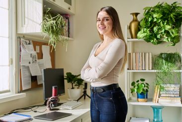 Portrait of young confident smiling woman in home interior