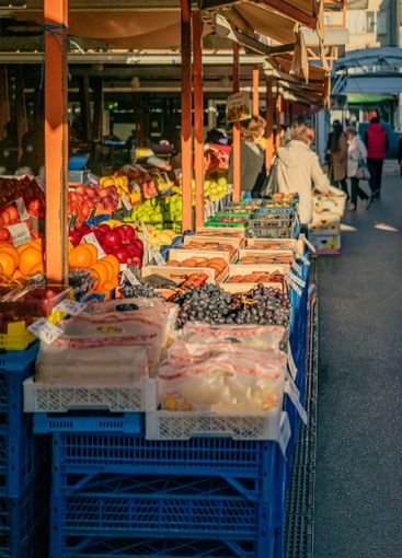 Outdoor fruit market with sunlight illuminating fresh...