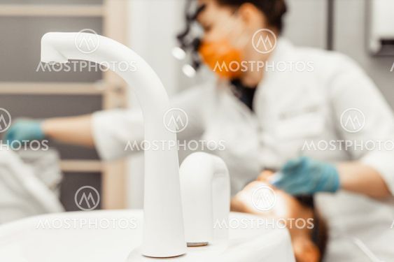 Dentist young woman treats a patient a man. The doctor...
