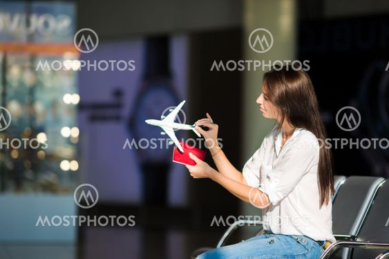 Pretty young female passenger with small model airplane...
