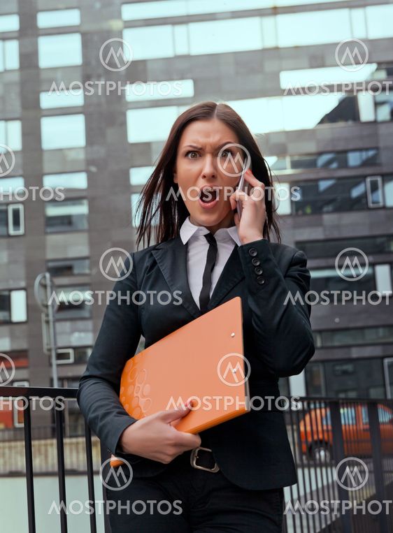 Beautiful angry business woman screaming in her phone