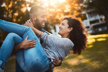 Carry, happy and couple with fun at park for sunset...