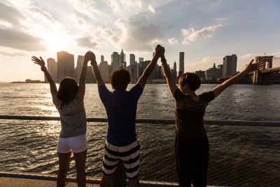Happy Japanese Tourists with Raised Arms in New York