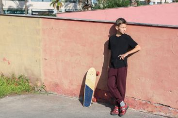 Handsome teenager standing with skateboard. Adolescent...