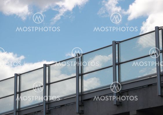 Metal and glass railing with blue sky perspective