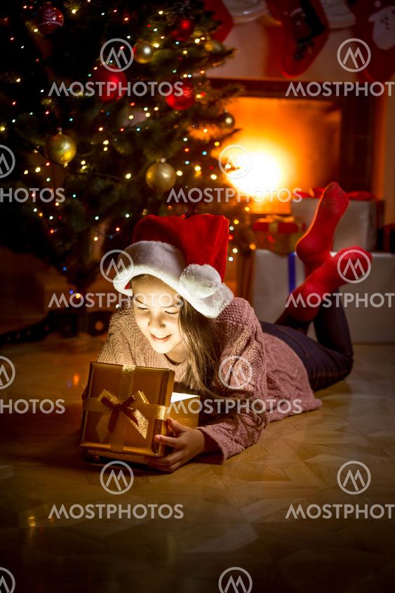 girl lying on floor at fireplace and looking inside of...