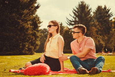 Moody girl with boyfriend in park. 