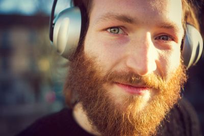 young stylish bearded man listening to music