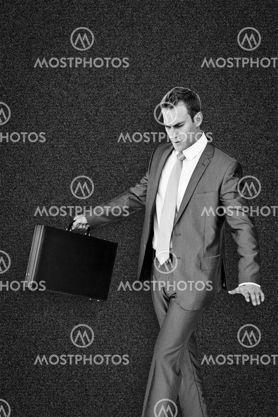 Composite image of businessman walking with his briefcase