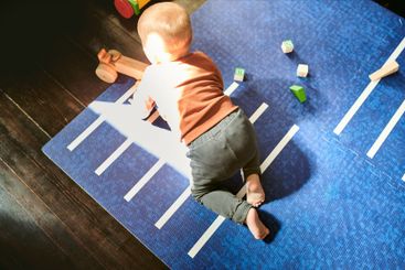 Above, baby and boy with toys on floor for building,...