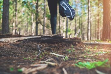 Woman, feet and athlete running in forest, outdoor...