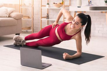 Coronavirus quarantine isolation. Fit woman doing side...