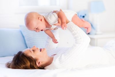 Mother and baby on a white bed