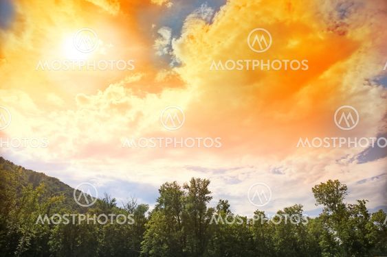 sun in clouds over wood