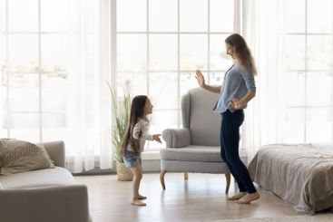 Millennial mommy dance with little daughter girl at...