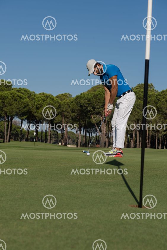 golf player hitting shot at sunny day