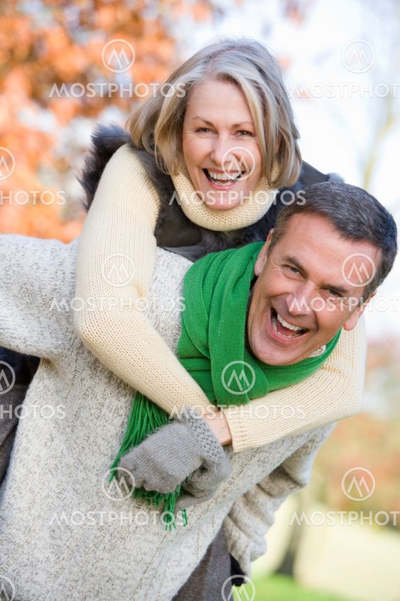 Senior man giving woman piggyback ride