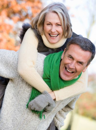Senior man giving woman piggyback ride