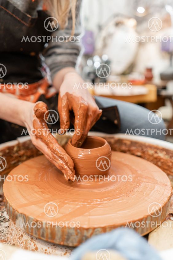 Craftsman hands making pottery bowl. Woman working on...