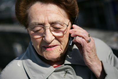 Elderly lady making a call outdoors