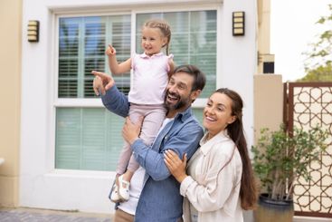 Cheerful couple of parents holding sweet daughter girl...