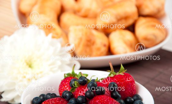 Breakfast with berries, milk and croissant
