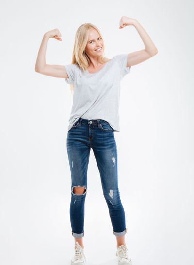 Full length portrait of a smiling woman showing her muscles