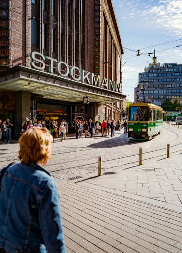 Pedestrians and tram on city street in Helsinki, Finland
