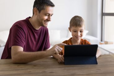 Dad and little son watching educational videos on tablet